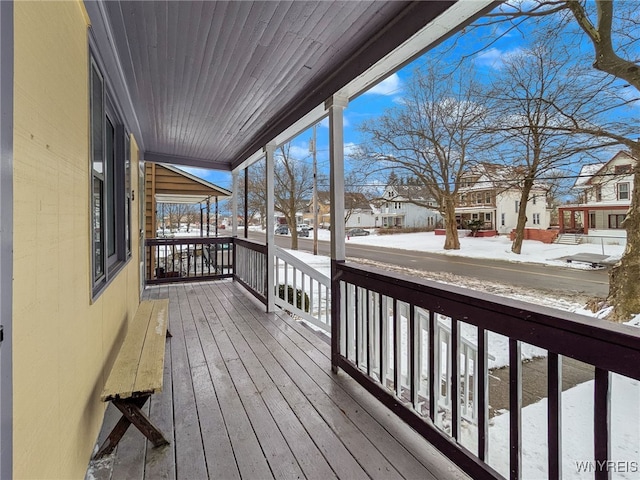 snow covered deck featuring a porch