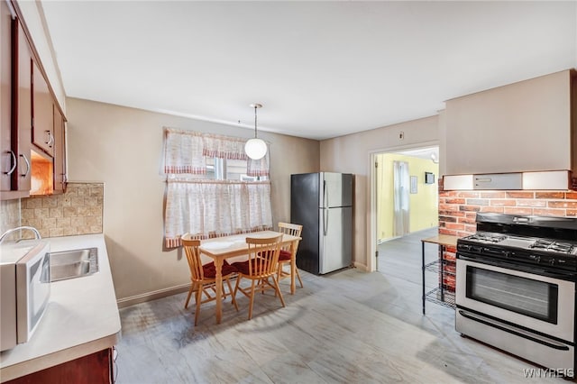 kitchen featuring hanging light fixtures, appliances with stainless steel finishes, and tasteful backsplash