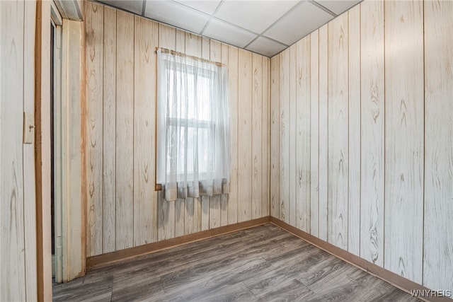 unfurnished room with a drop ceiling and dark hardwood / wood-style flooring