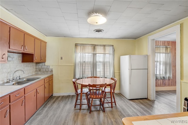 kitchen featuring a wealth of natural light, decorative backsplash, sink, and white refrigerator