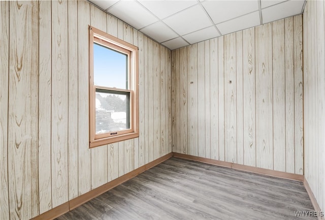 empty room featuring hardwood / wood-style floors and a drop ceiling