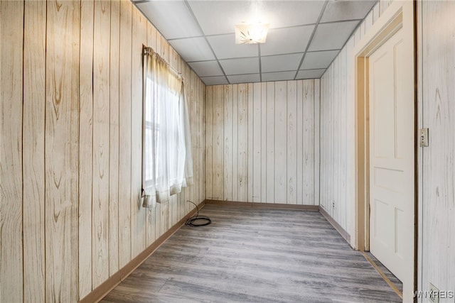 empty room with wood-type flooring and a drop ceiling