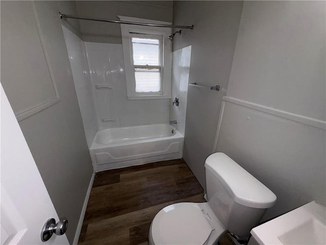 bathroom with bathtub / shower combination, toilet, and hardwood / wood-style floors