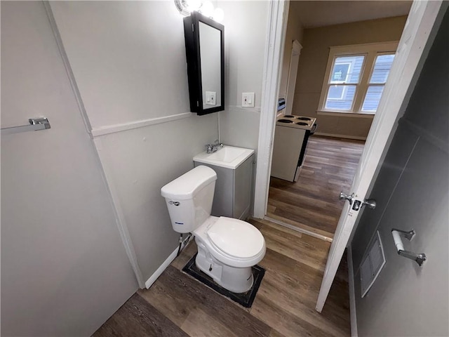 bathroom with sink, hardwood / wood-style floors, and toilet