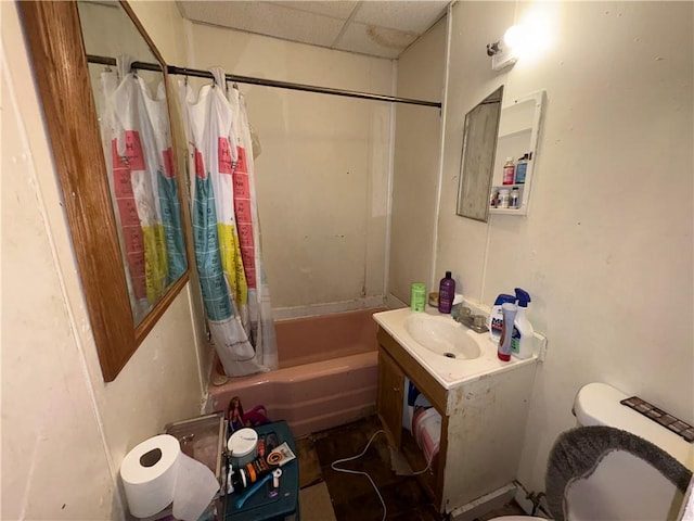 full bathroom featuring sink, a drop ceiling, toilet, and shower / bath combination with curtain