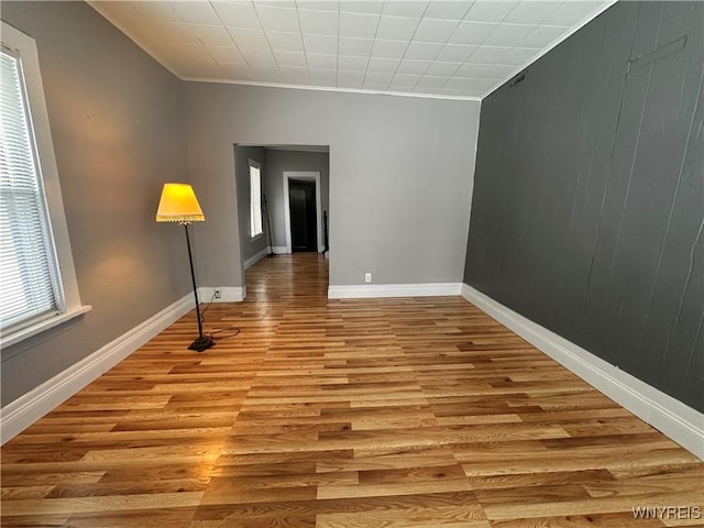 unfurnished room with light hardwood / wood-style floors and crown molding