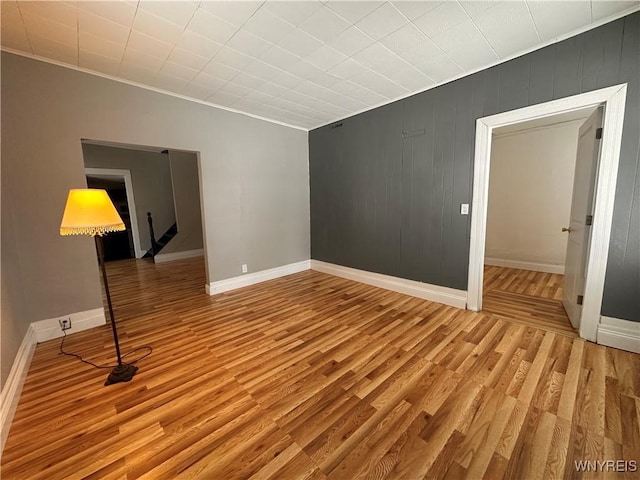 unfurnished living room featuring ornamental molding and light hardwood / wood-style floors