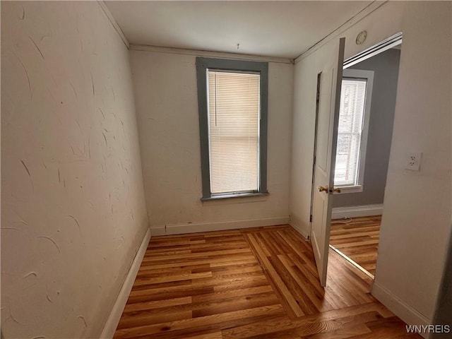 unfurnished room featuring wood-type flooring and ornamental molding