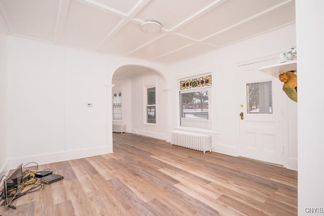 unfurnished room featuring coffered ceiling, hardwood / wood-style flooring, and radiator heating unit