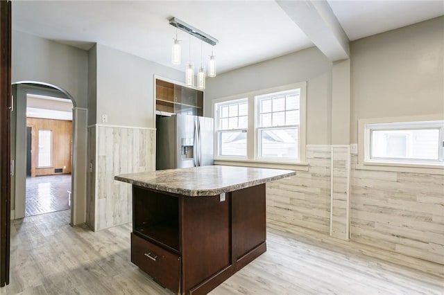 kitchen with light hardwood / wood-style flooring, stainless steel fridge, dark brown cabinetry, and a center island