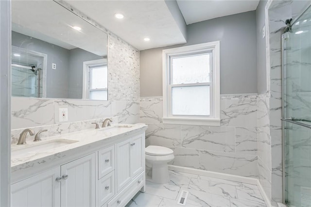 bathroom featuring toilet, plenty of natural light, an enclosed shower, and vanity