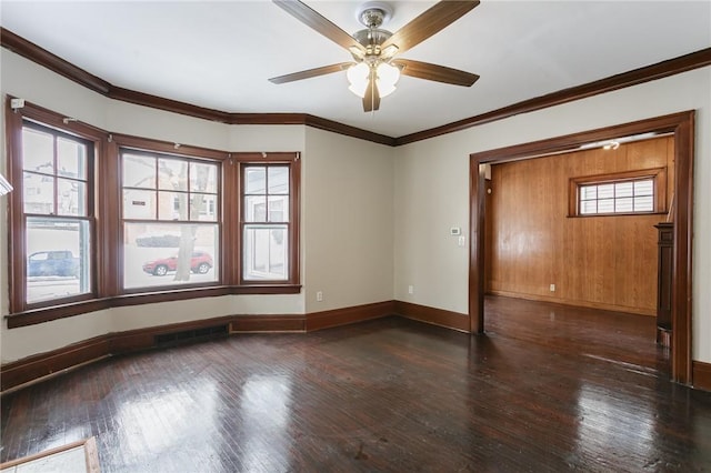 spare room featuring plenty of natural light, dark hardwood / wood-style flooring, and crown molding