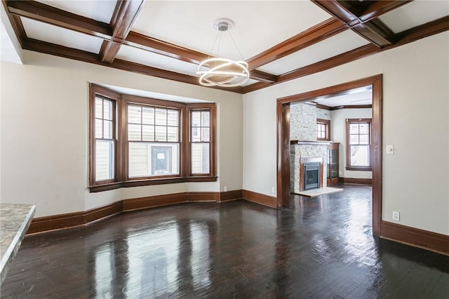 unfurnished living room with coffered ceiling, a large fireplace, dark hardwood / wood-style flooring, a chandelier, and beam ceiling