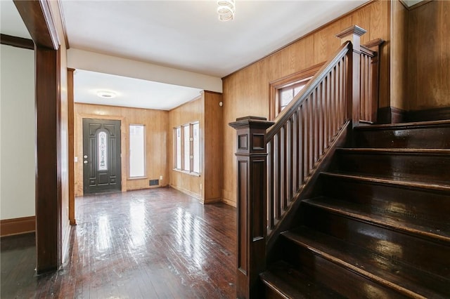 entrance foyer featuring crown molding, wood walls, and hardwood / wood-style flooring