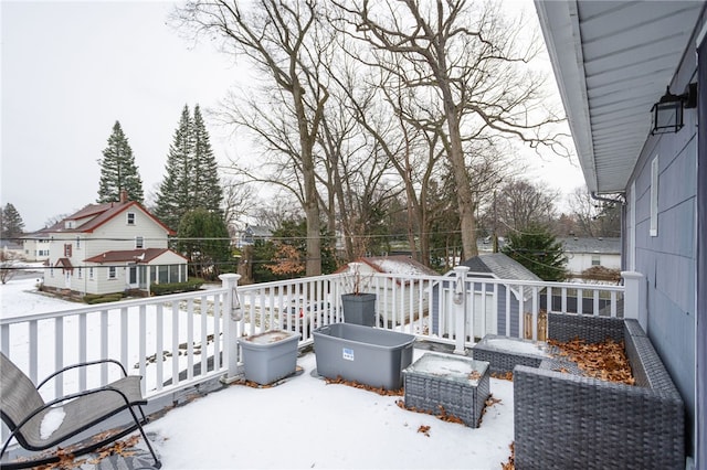 snow covered patio featuring a wooden deck