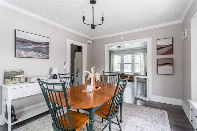 dining space with ceiling fan with notable chandelier, a textured ceiling, dark hardwood / wood-style floors, and ornamental molding