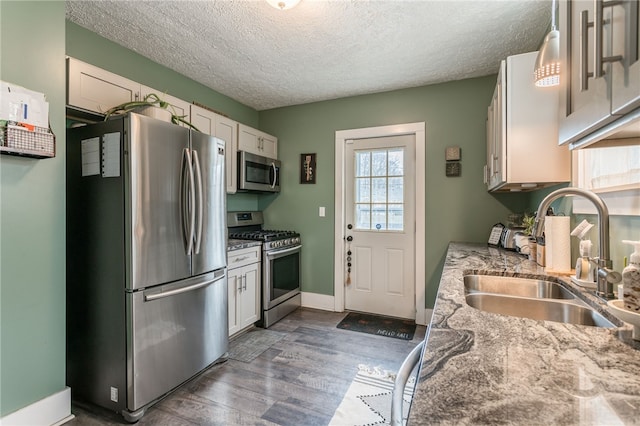 kitchen featuring light stone countertops, appliances with stainless steel finishes, sink, and white cabinetry