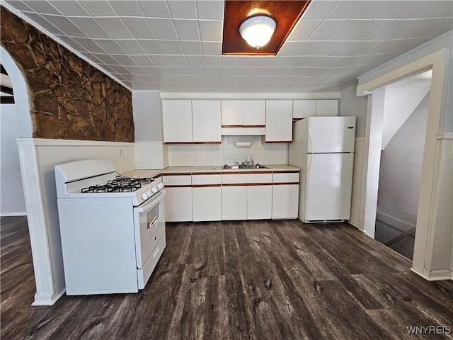 kitchen with tasteful backsplash, dark hardwood / wood-style floors, sink, white appliances, and white cabinetry