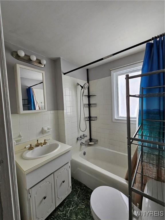 full bathroom featuring shower / bath combo with shower curtain, decorative backsplash, toilet, and vanity