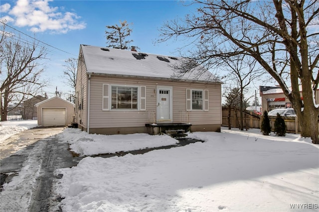 view of front of home with a garage and an outbuilding