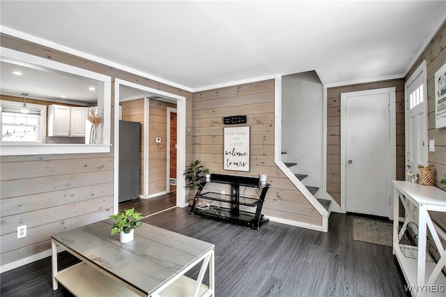 living room with crown molding, dark hardwood / wood-style floors, and wood walls