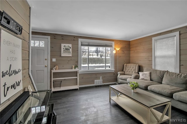 living room with dark hardwood / wood-style floors and wood walls