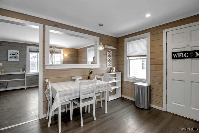 dining area featuring a healthy amount of sunlight and wooden walls