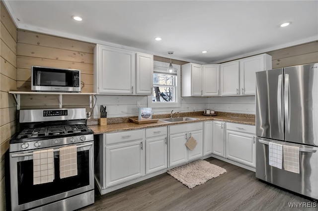 kitchen featuring white cabinetry, appliances with stainless steel finishes, dark wood-type flooring, dark stone countertops, and sink