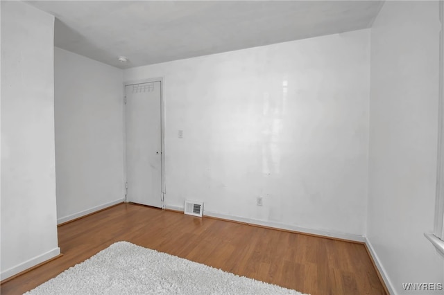 empty room with hardwood / wood-style flooring