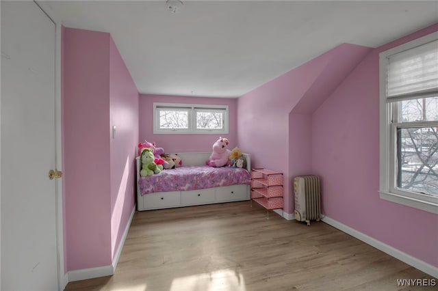 bedroom featuring radiator and light hardwood / wood-style floors