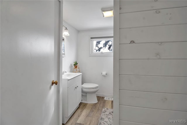 bathroom with toilet, vanity, and hardwood / wood-style floors