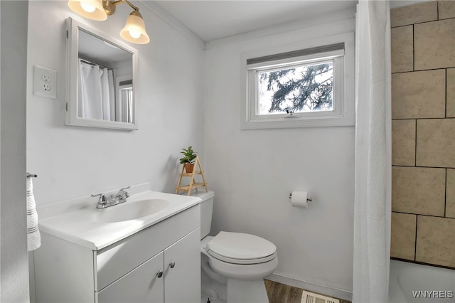 bathroom with wood-type flooring, toilet, vanity, and walk in shower