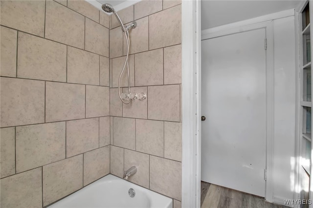 bathroom featuring tiled shower / bath combo and hardwood / wood-style flooring