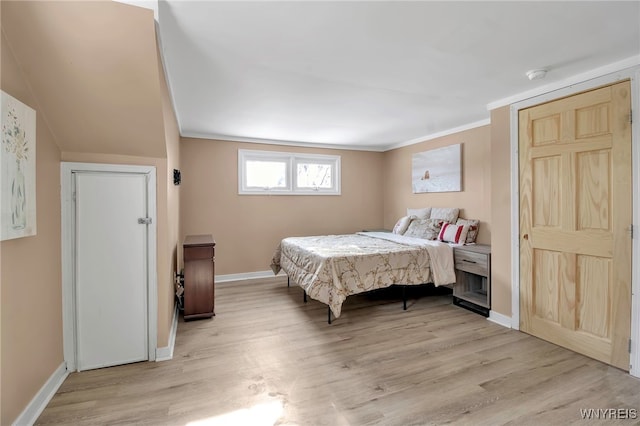 bedroom featuring ornamental molding and light hardwood / wood-style floors