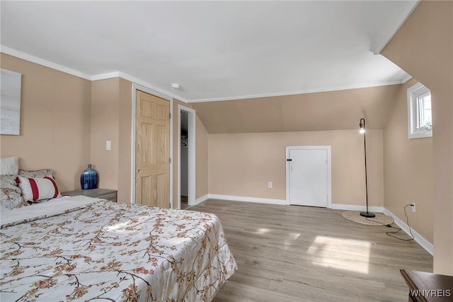 bedroom featuring vaulted ceiling, a closet, and hardwood / wood-style flooring