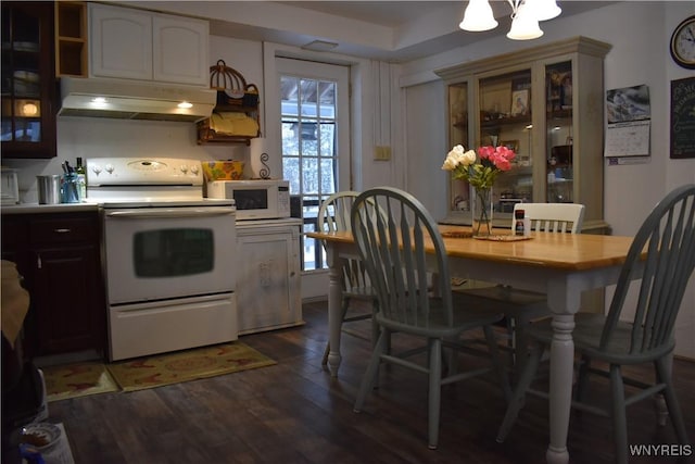 kitchen featuring dark wood-type flooring, an inviting chandelier, and white appliances