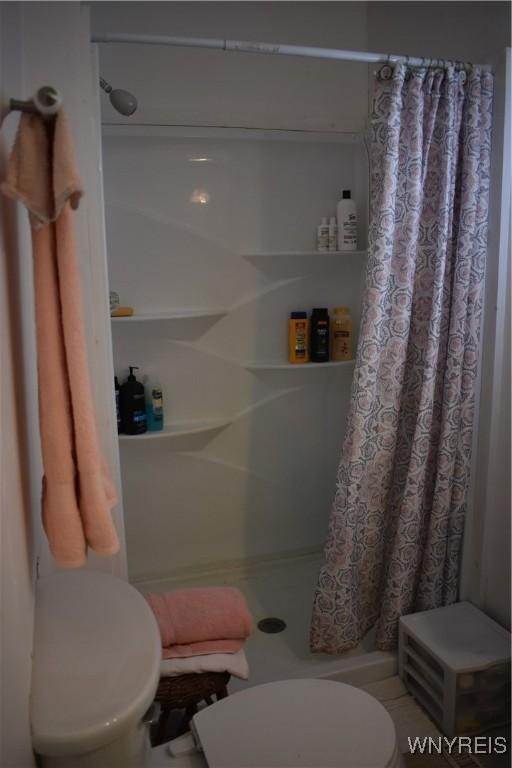 bathroom with walk in shower and toilet