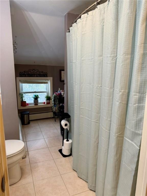 bathroom featuring a baseboard heating unit, toilet, and tile patterned floors