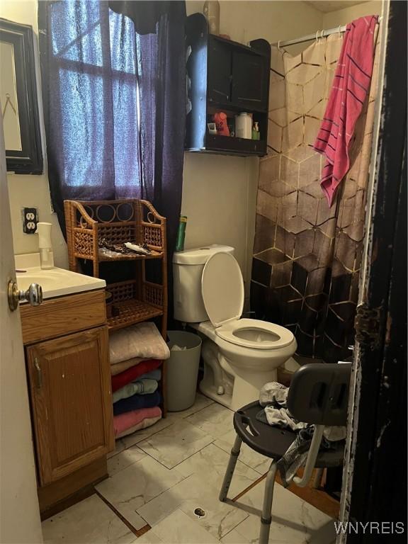 bathroom with curtained shower, toilet, and vanity