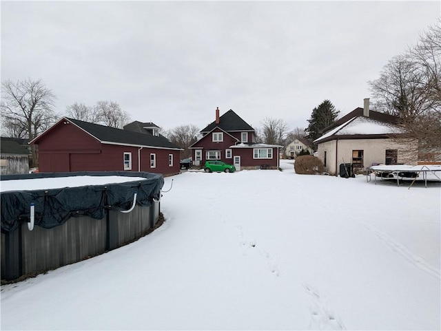 yard covered in snow featuring a covered pool