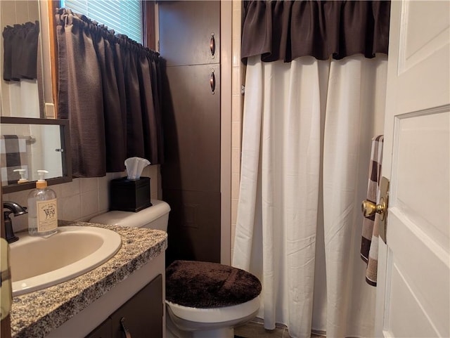 bathroom with decorative backsplash, toilet, and vanity