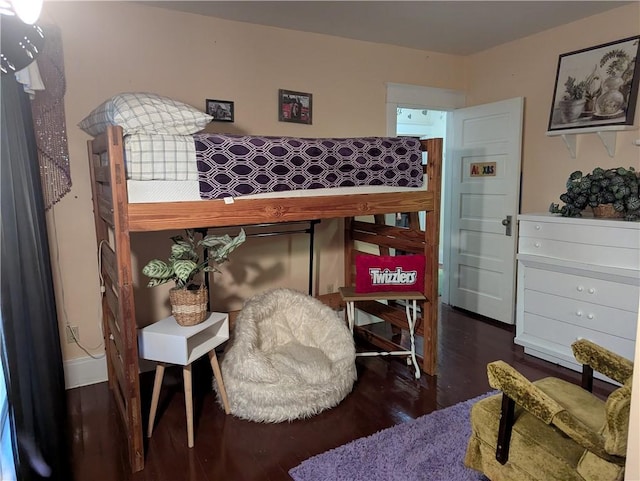 bedroom with dark hardwood / wood-style flooring