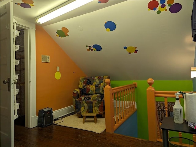 bedroom featuring lofted ceiling, a nursery area, and dark hardwood / wood-style flooring