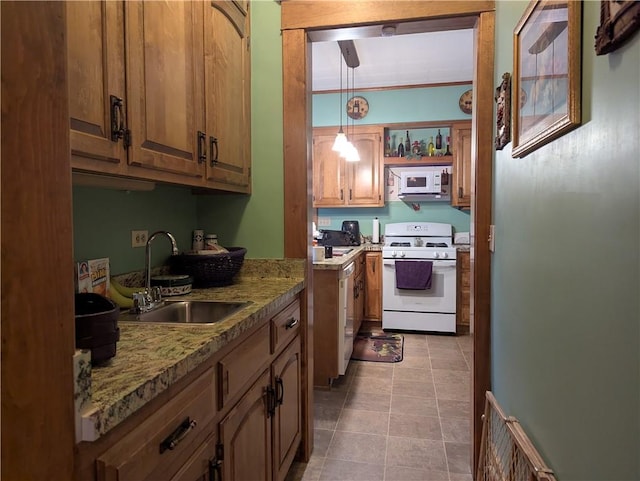 kitchen featuring white appliances, decorative light fixtures, sink, light stone counters, and light tile patterned floors