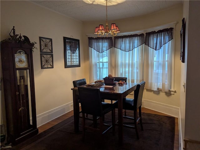 dining area with dark hardwood / wood-style flooring and a chandelier