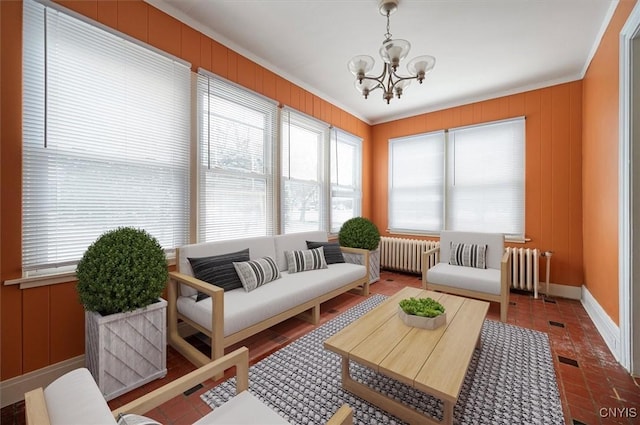 sunroom with radiator, a chandelier, and a healthy amount of sunlight