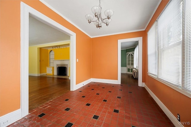 unfurnished dining area featuring dark tile patterned flooring, ornamental molding, and a chandelier