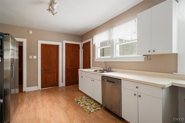 kitchen with white cabinets, light wood-type flooring, sink, and stainless steel appliances