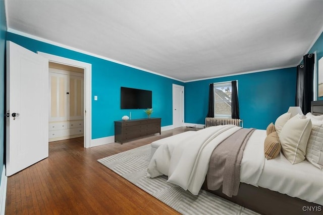 bedroom with radiator, ornamental molding, and wood-type flooring