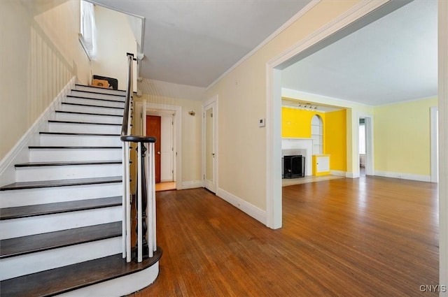 staircase featuring ornamental molding and hardwood / wood-style flooring